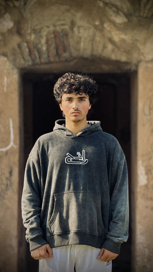 Person wearing Acid Wash Hoodie with a logo puffed printed in front.